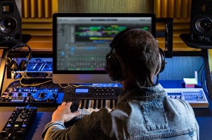 Photo d'un jeune devant un logiciel de production musicale